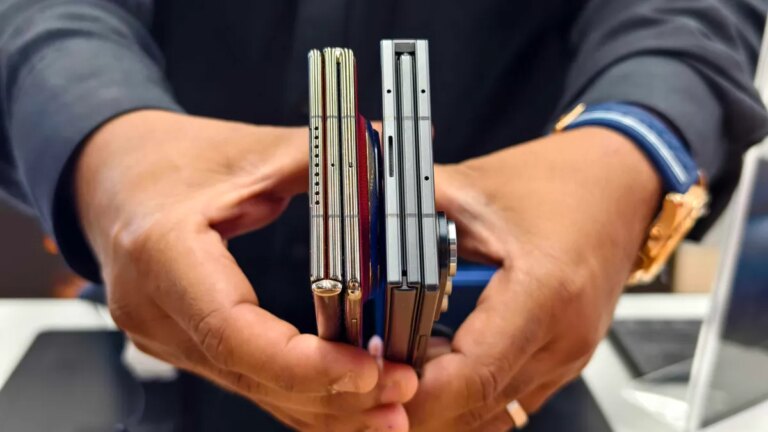 A person holding the folded Huawei Mate XT and Samsung Galaxy Z TriFold.