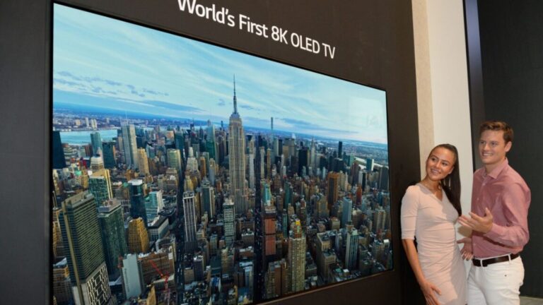The TV industry finally concedes that the future may not be in 8K A man and woman standing next to a TV labeled the "world's first 8K OLED TV."