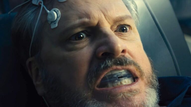 closeup of a man with electrode attached to forehead and a mouth guard looking alarmed