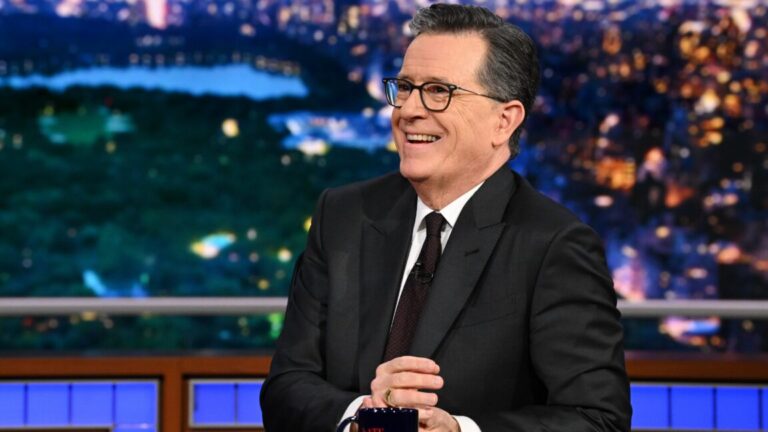 Stephen Colbert says CBS forbid interview of Democrat because of FCC threat Stephen Colbert sits at his desk and smiles on the set of his late-night TV show.
