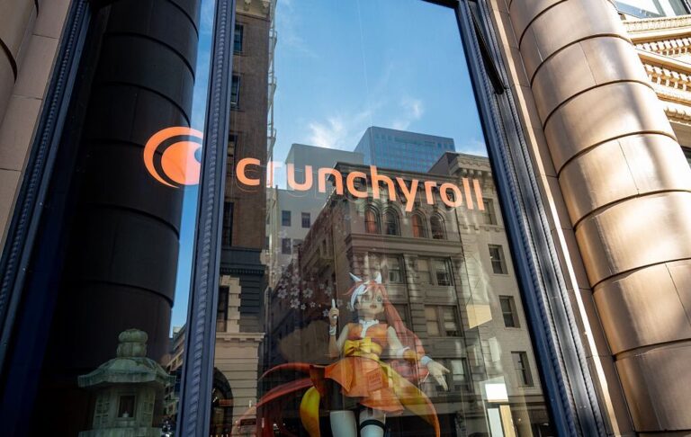 Logo for Crunchyroll on window with anime figure visible inside window.
